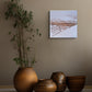 Decorative scene with brown ceramic pots and a plant against a beige wall with a framed artwork.